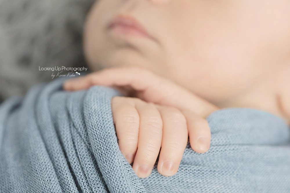 Baby boy swaddled in blue with precious tiny hands for newborn session baby portrait
