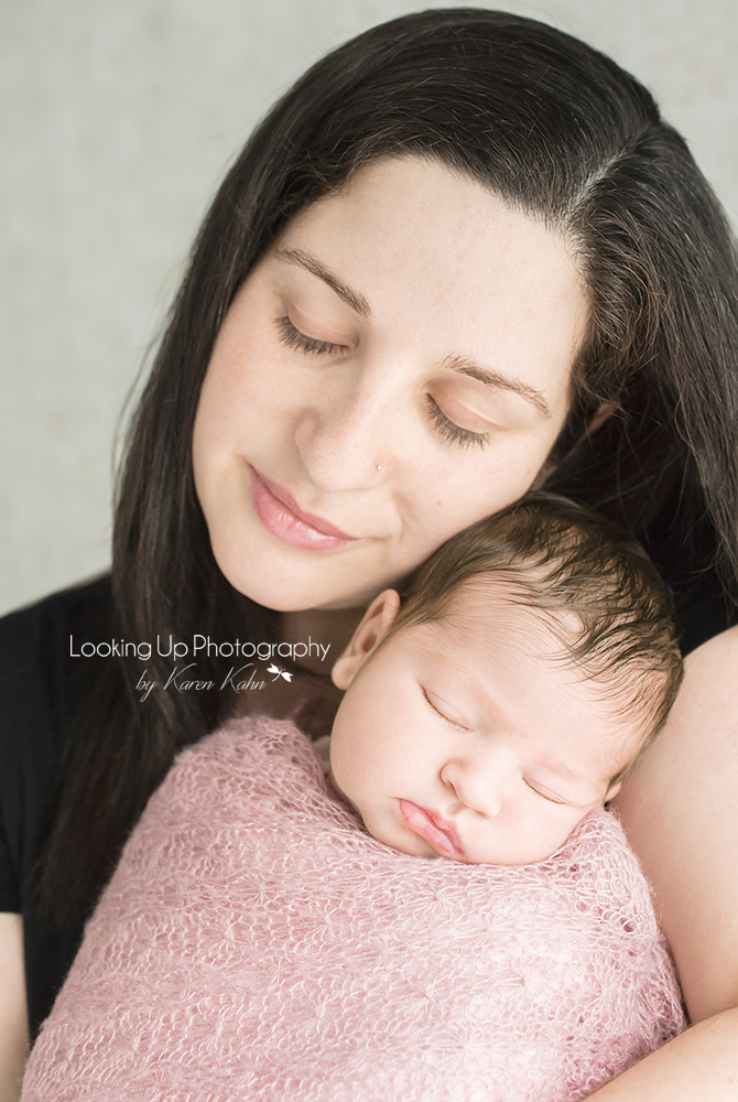 Mommy and baby girl cuddling with soft pink lace wrap for newborn portrait session