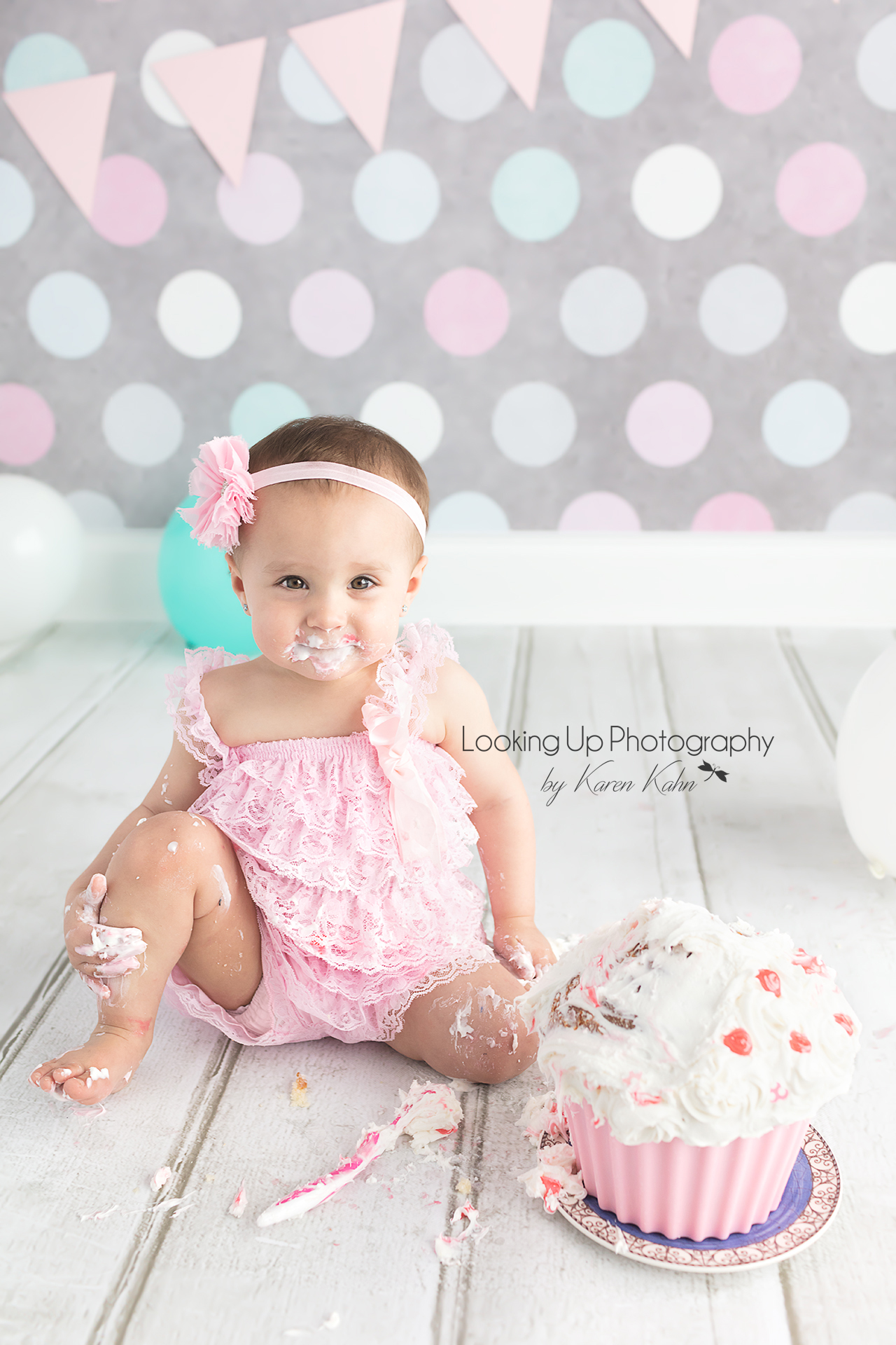 Pink lace for adorable 12 month milestone for baby girl looking sweet with gray polka dots for cake smash session one year old portrait