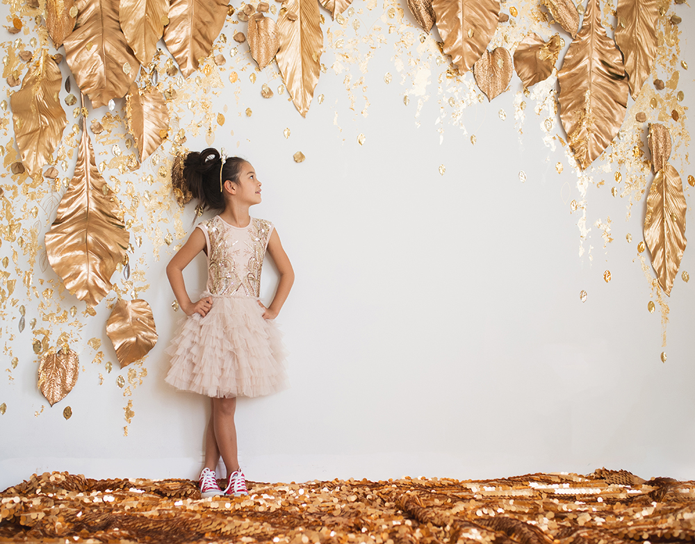 Fall holiday portrait session with girl with golden dress and red sneakers in festive Joyful Gatherings gold set design