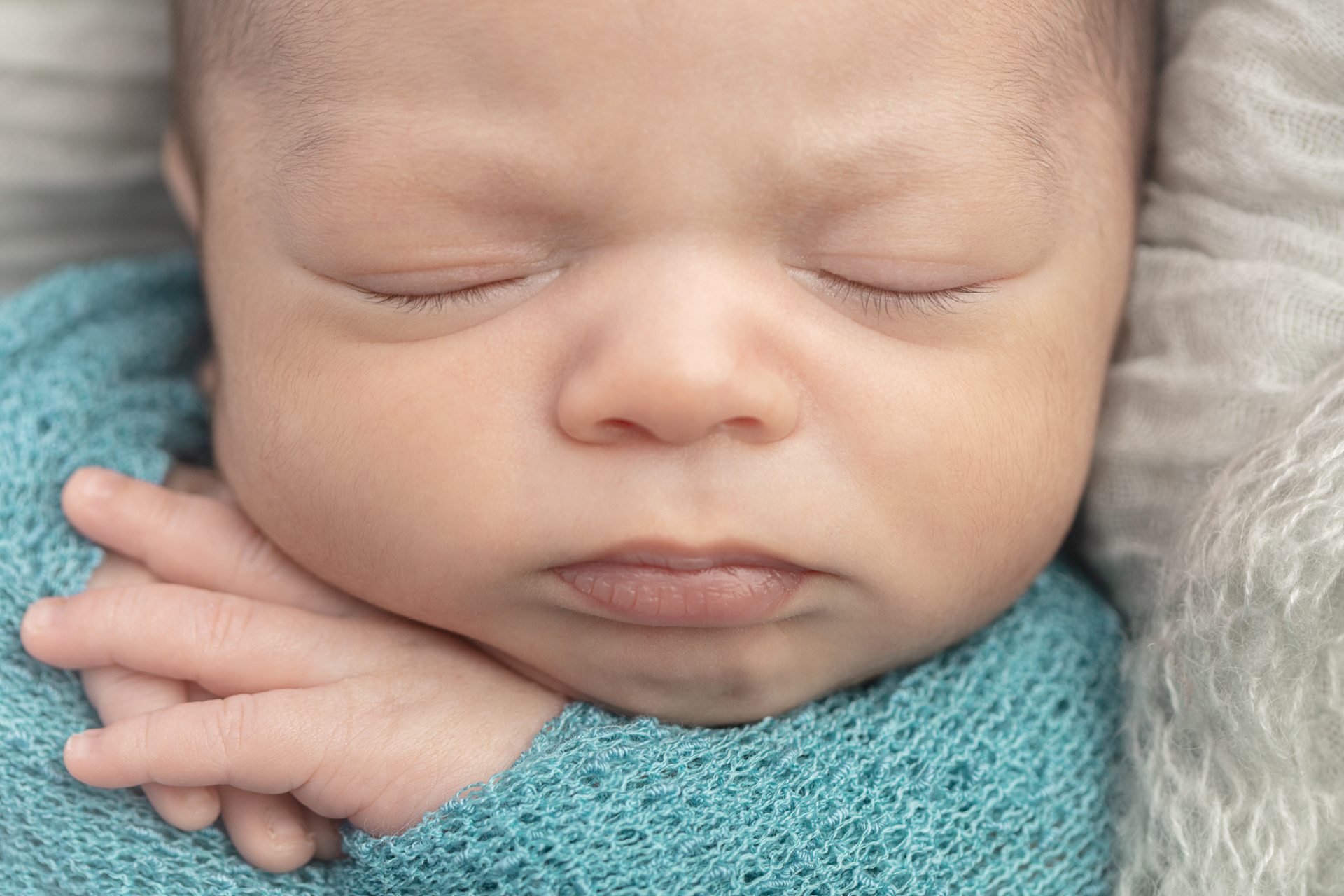 close up picture of a newborn baby boy with his hands folded under his chin; Greenwich newborn photography