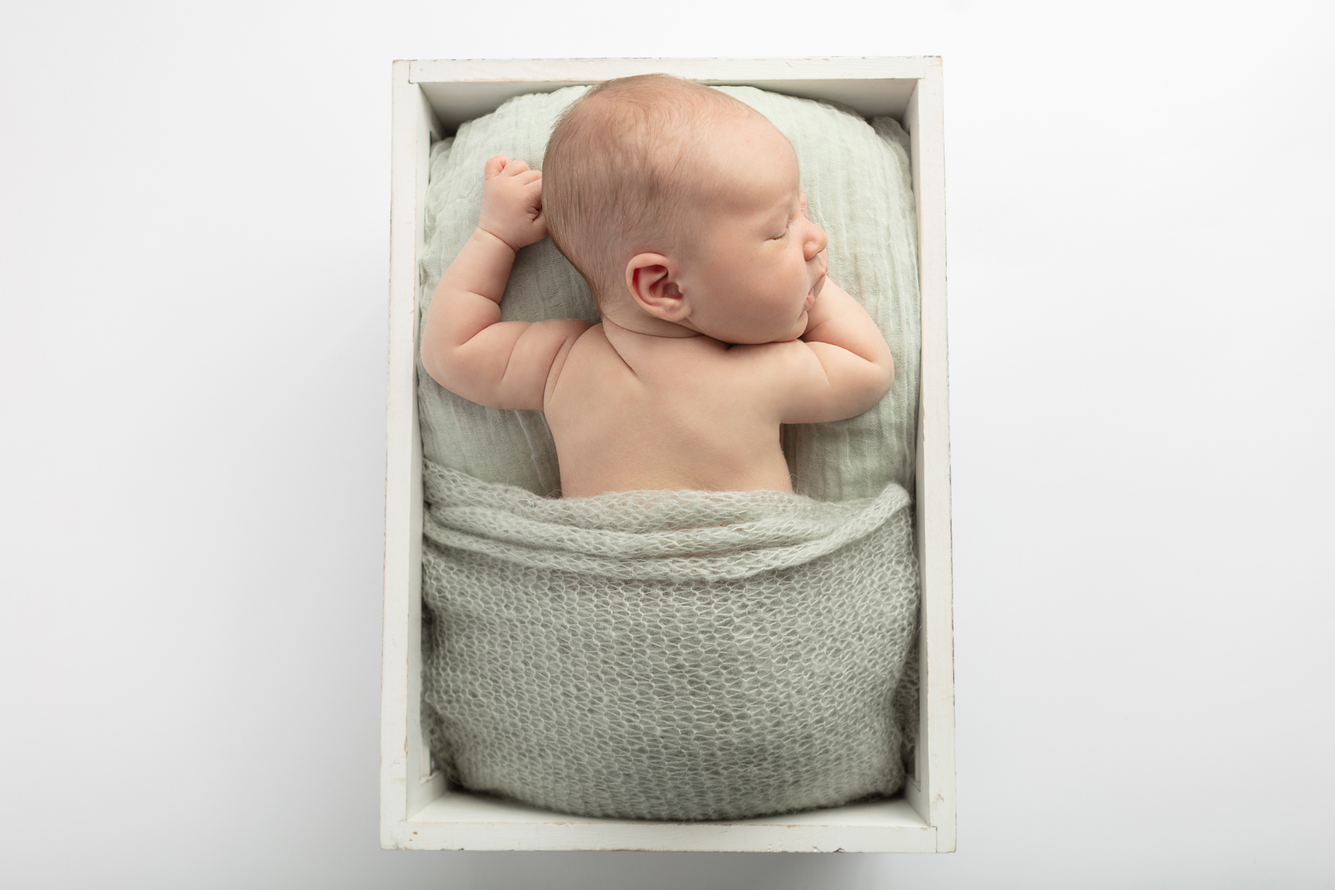 Greenwich newborn photographer; newborn boy in a box; Looking Up Photography