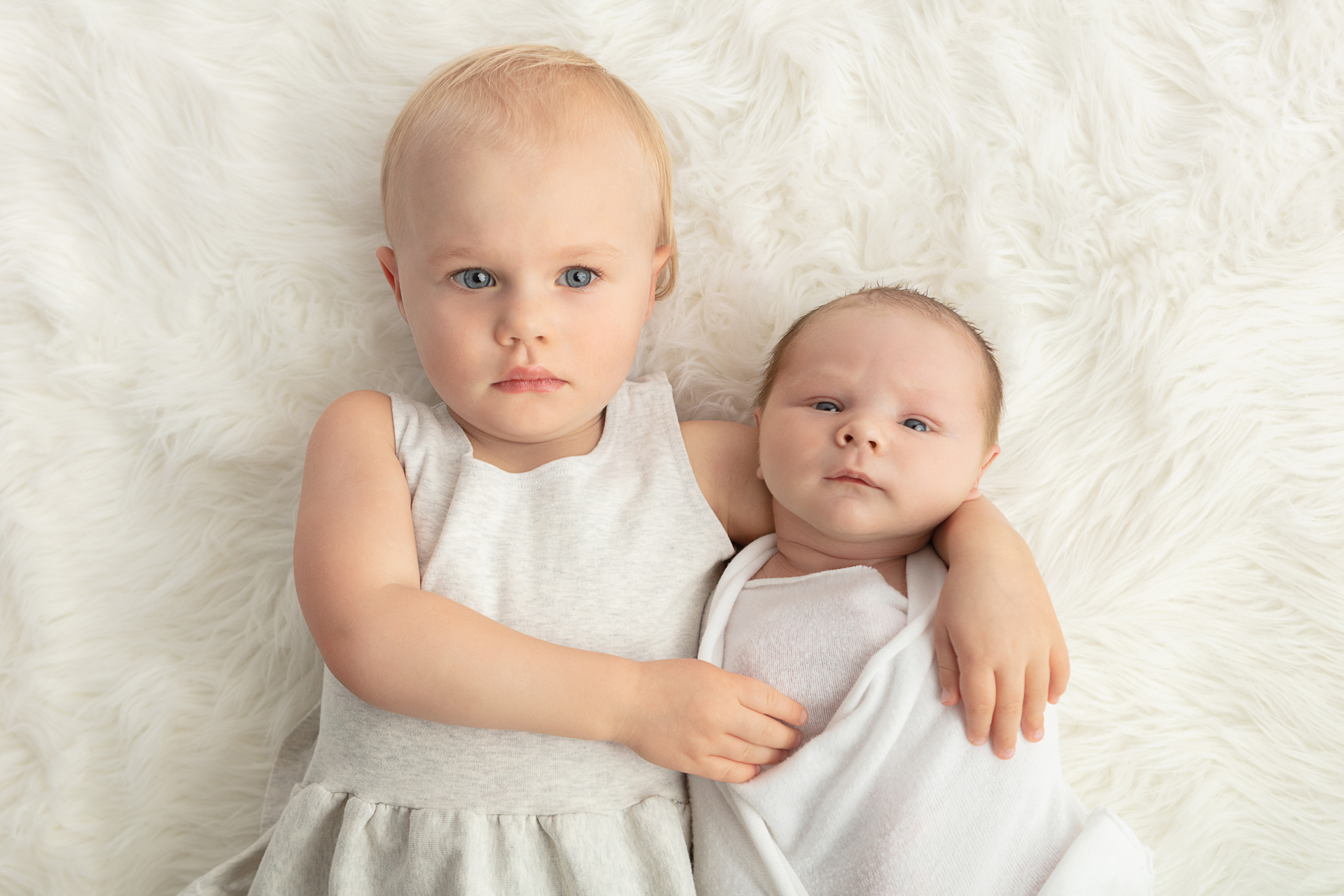newborn photography with sibling; white flokati