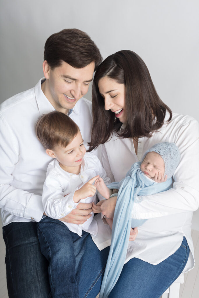 A family of four is classically photographed at the Looking Up Photography studio in Greenwich, Connecticut.
