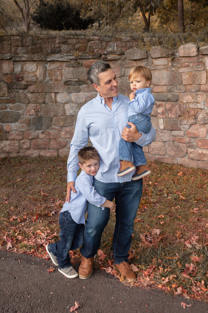 Father enjoying quality time with his two young sons, playing together and sharing joyful moments. Photographed by Karen Kahn of Looking Up Photography