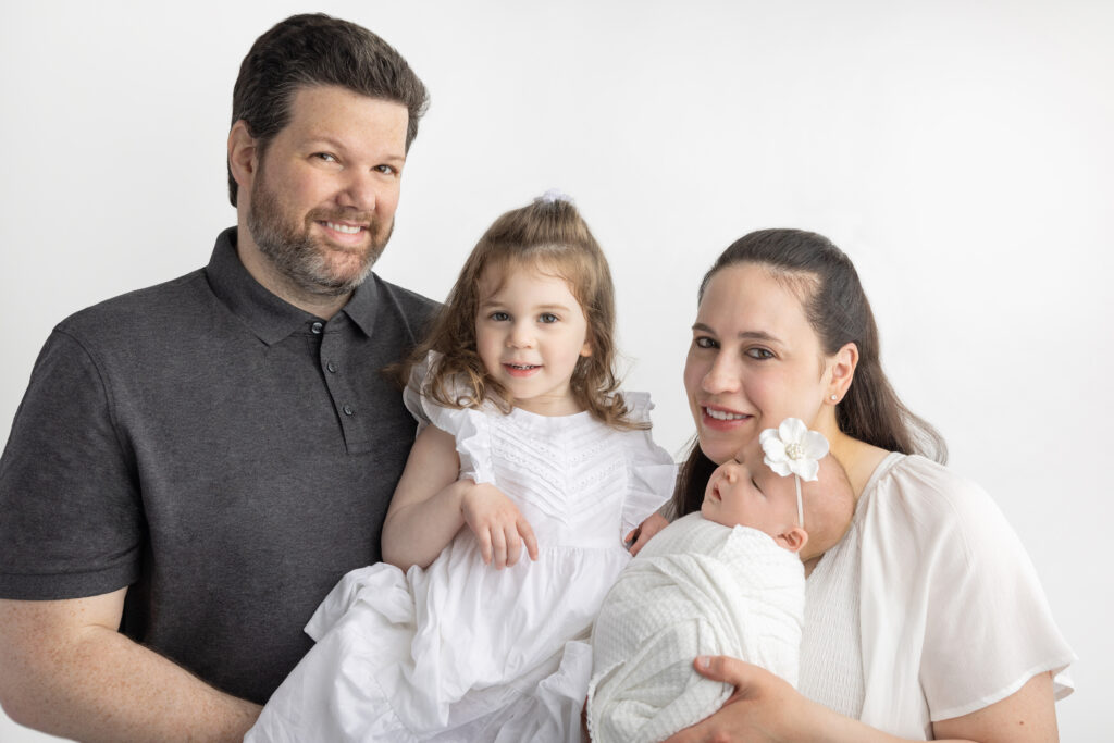 A newly minted family of four is photographed in the Looking Up Photography studio in Cos Cob, Greenwich, Connecticut, and are photographed by Karen Kahn