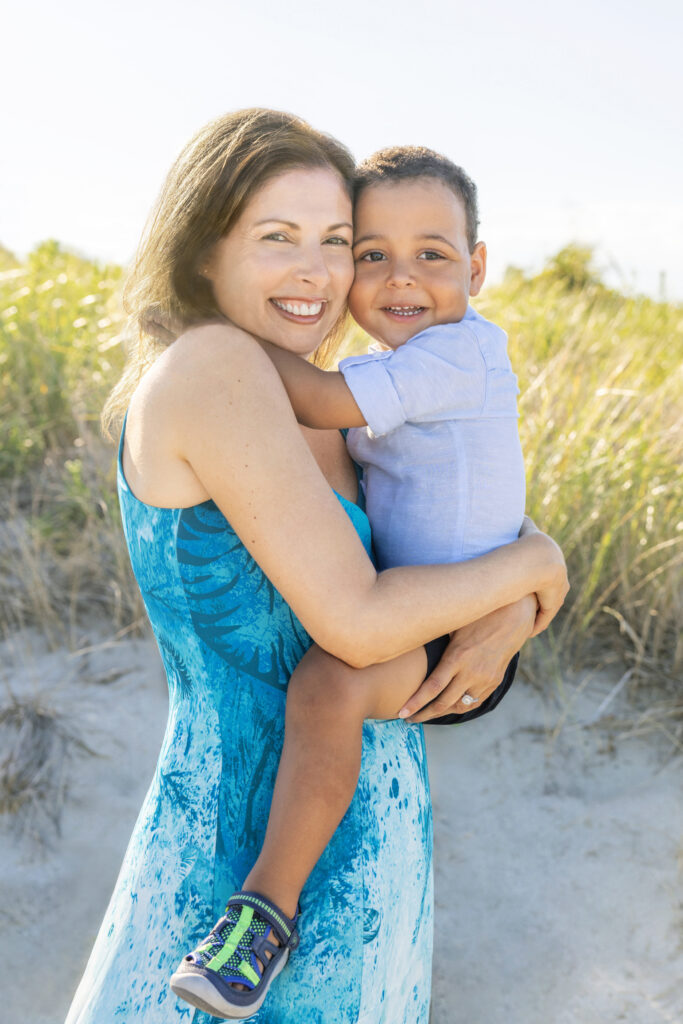 Mother and son are photographed in celebration of the boy's second birthday. Mom holds her little boy close as the pair smile at the camera, photographed by Karen Kahn of Looking Up Photography.